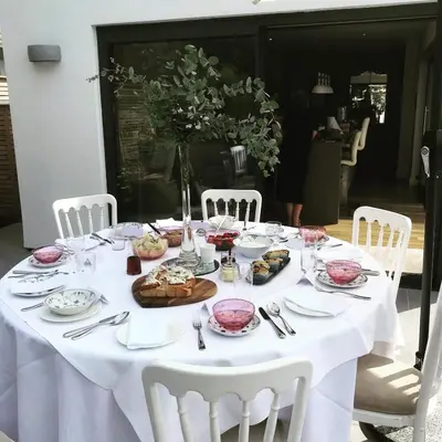 a white table with white chairs and a table with food on it at Frinton45 in Frinton-on-Sea