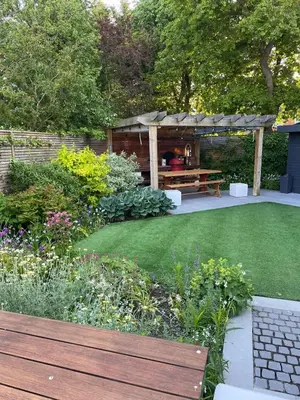 a garden with a wooden bench and a gazebo at Frinton45 in Frinton-on-Sea