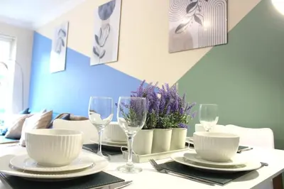 a table with plates and wine glasses on it at STN - Bishops's Stortford - Free Gated Parking - Two Bed Apartment - Perfect location for Stansted Airport in Bishops Stortford