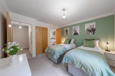two beds in a room with green walls at STN - Bishops's Stortford - Free Gated Parking - Two Bed Apartment - Perfect location for Stansted Airport in Bishops Stortford