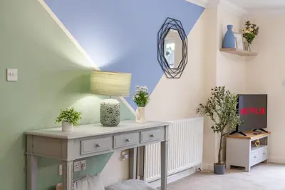 a room with a table with a lamp and a mirror at STN - Bishops's Stortford - Free Gated Parking - Two Bed Apartment - Perfect location for Stansted Airport in Bishops Stortford