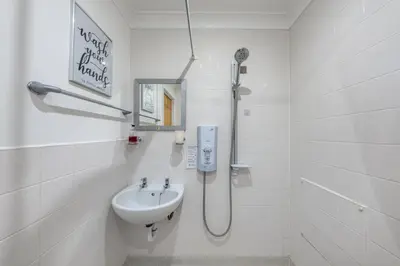 a white bathroom with a sink and a shower at STN - Bishops's Stortford - Free Gated Parking - Two Bed Apartment - Perfect location for Stansted Airport in Bishops Stortford