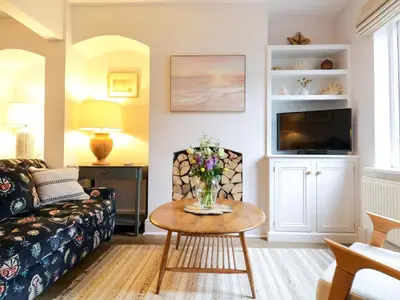 a living room with a couch and a table at Compass Cottage in Aldeburgh
