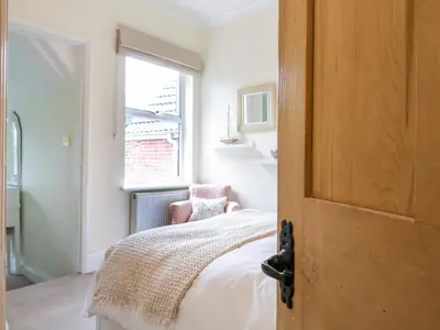 a bedroom with a bed and a window at Compass Cottage in Aldeburgh