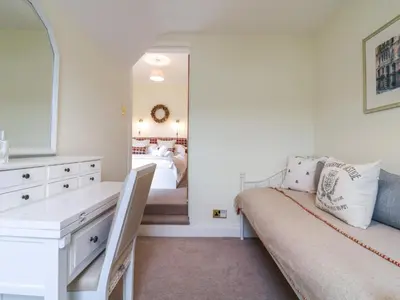 a bedroom with a bed and a dresser and a mirror at Compass Cottage in Aldeburgh