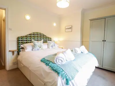 a bedroom with a bed with towels on it at Compass Cottage in Aldeburgh