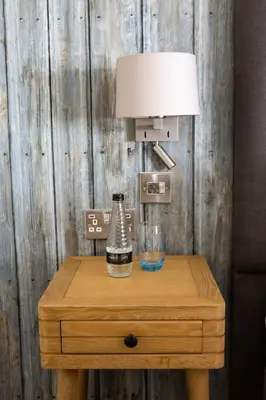 a table with a lamp and a glass on it at The Brudenell in Aldeburgh