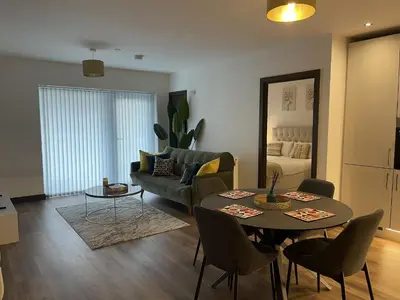 a living room with a table and a couch at The Melodies with Free Parking , Harlow in Harlow