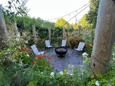 a group of chairs and a fire pit in a garden at River Mill Retreat in Little Hallingbury