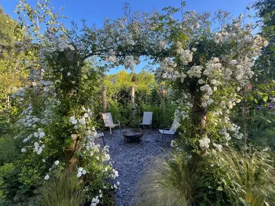 a garden with a large arch of flowers at River Mill Retreat in Little Hallingbury