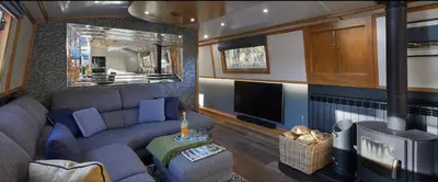 a living room with a couch and a flat screen tv at River Mill Retreat in Little Hallingbury