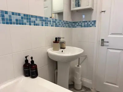 a white bathroom with a sink and a toilet at Sunny Beachside Apt with Free Parking in Southend-on-Sea