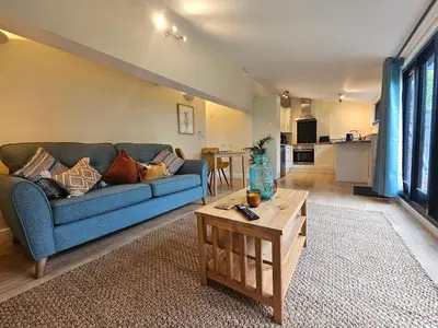a living room with a blue couch and a table at Lilys Cottage - Sleeps 2 - Pet friendly in Stowmarket