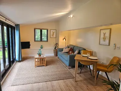 a living room with a blue couch and a table at Lilys Cottage - Sleeps 2 - Pet friendly in Stowmarket