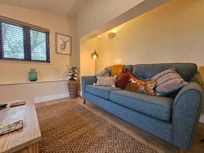 a living room with a blue couch with pillows on it at Lilys Cottage - Sleeps 2 - Pet friendly in Stowmarket
