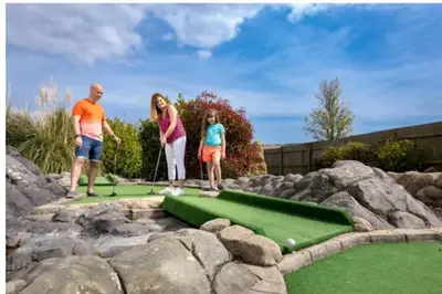 a group of people playing a game of mini golf at Modern & Blissful Beach Park Holiday Home in Dovercourt, Essex, in Parkeston
