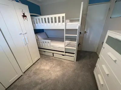 a baby room with a white crib and bunk bed at Spacious House Near Cambridge - Free Parking and Garden in Cambridge