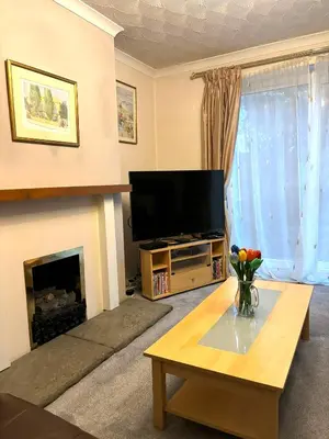 a living room with a television and a fireplace at Spacious House Near Cambridge - Free Parking and Garden in Cambridge