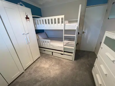 a baby room with a white crib and bunk bed at Spacious House Near Cambridge - Free Parking and Garden in Cambridge