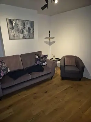 a living room with a couch and a chair at Sizewell - Contractors - Free Parking - Vacation in Leiston