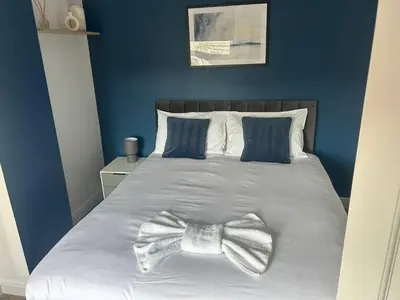 a bedroom with a bed with a bow tie on it at Sizewell - Contractors - Free Parking - Vacation in Leiston