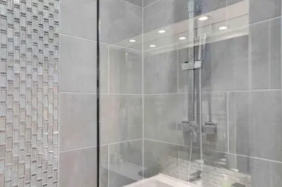 a shower with a glass door in a bathroom at Chelmer Springs Maisonettes in Chelmsford