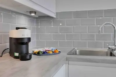 a kitchen counter with a coffee maker and a plate of food at Chelmer Springs Maisonettes in Chelmsford
