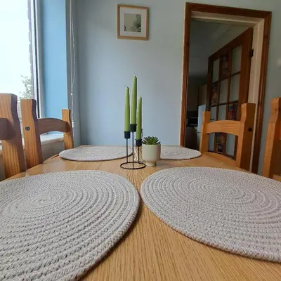 a dining room table with three circular rugs on it at Cute little 2 bed near Cambridge in Fenstanton