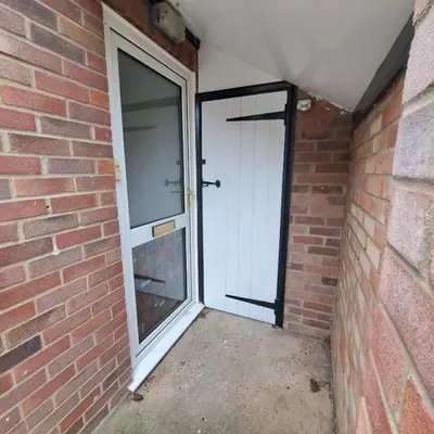 a door in a brick building with a brick wall at Cute little 2 bed near Cambridge in Fenstanton