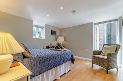 a bedroom with a bed and a chair and windows at 1 Bed in Cratfield oc-t29434 in Cratfield