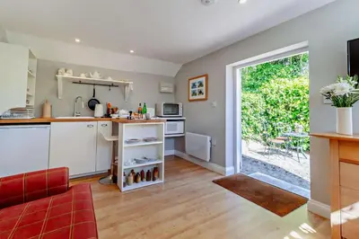 a kitchen and living room with a red couch at 1 Bed in Cratfield oc-t29434 in Cratfield