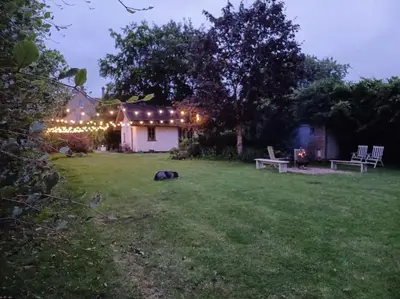 a yard with a house with lights on it at Straw Bale Cottage in Halesworth