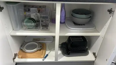 a white cabinet with various kitchen items in it at DK House in Colchester