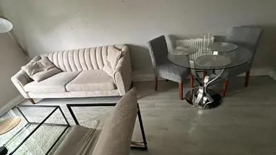 a living room with a white couch and a glass table at DK House in Colchester