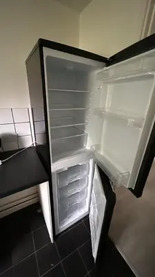 an empty refrigerator with its door open in a room at DK House in Colchester
