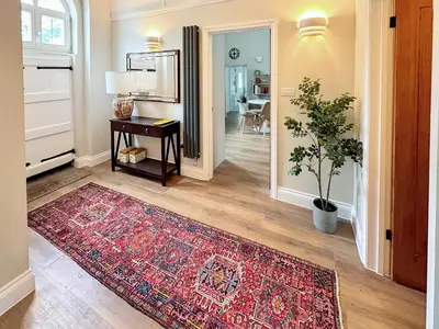 a living room with a rug on the floor and a table at The Church Rooms in Wenhaston