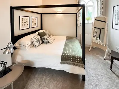 a bedroom with a large bed with a black frame at The Church Rooms in Wenhaston