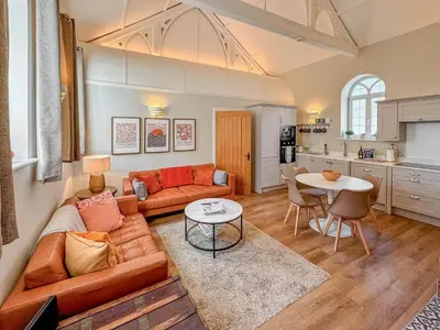 a living room with a couch and a table at The Church Rooms in Wenhaston
