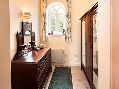 a kitchen with a wooden dresser and a window at The Church Rooms in Wenhaston