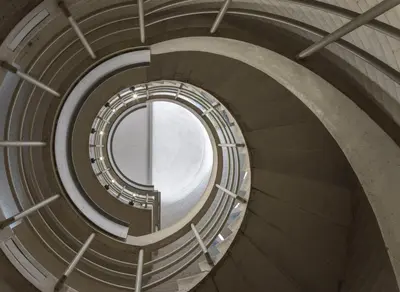 a spiral staircase in a building with a round window at Murray Edwards College, Cambridge in Cambridge