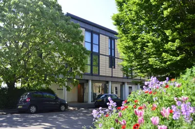 a building with cars parked in front of it at Murray Edwards College, Cambridge in Cambridge