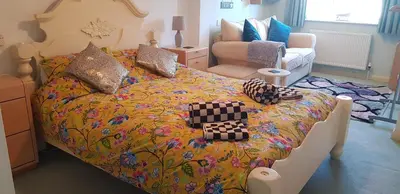 a bedroom with a large bed with a colorful bedspread at Mermaid Cottages in Frinton-on-Sea