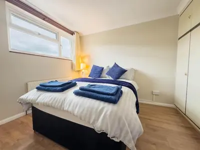 a bedroom with a bed with blue towels on it at Cousy Haven in Laindon