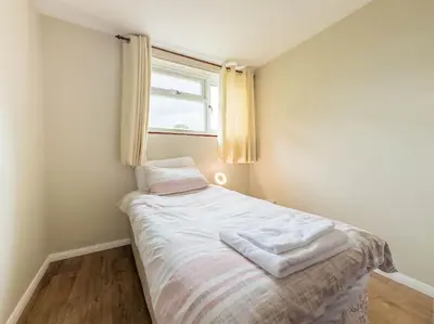a small bed in a room with a window at Cousy Haven in Laindon