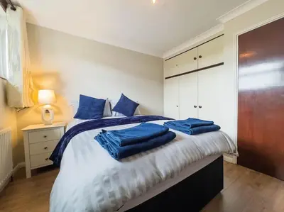 a bedroom with a bed with blue towels on it at Cousy Haven in Laindon