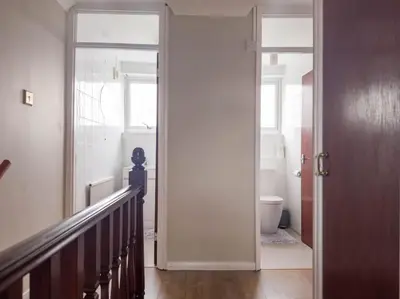a hallway with a door leading to a bathroom with a toilet at Cousy Haven in Laindon