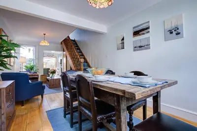 a kitchen and dining room with a wooden table and chairs at Stunning Cottage in the Heart of Old Leigh - Pass the Keys in Southend-on-Sea