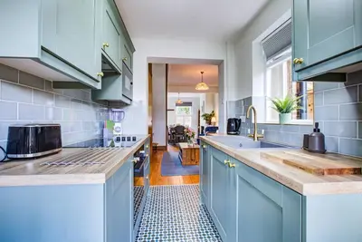 a kitchen with blue cabinets and a sink at Stunning Cottage in the Heart of Old Leigh - Pass the Keys in Southend-on-Sea
