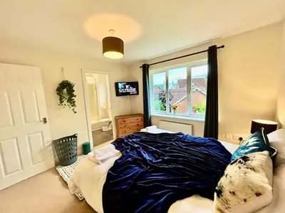 a bedroom with a bed with blue sheets and a window at 6 Bedroom House - DISC0UNTS - Parking, Contractors, Group, Family in Braintree