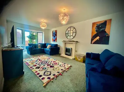 a living room with a blue couch and a rug at 6 Bedroom House - DISC0UNTS - Parking, Contractors, Group, Family in Braintree